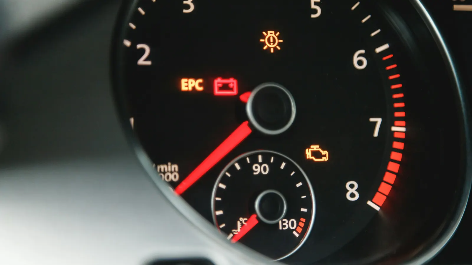 An amber check engine light and other warning lights lit on a car's instrument cluster