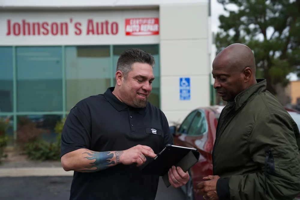 Johnson's Auto Repair mechanic reviewing a repair with a customer outside the shop in Lake Elsinore